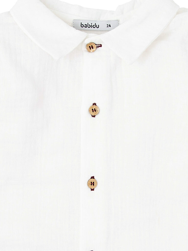 Detalle de la camisa de bebé niño blanca de gasa de algodón