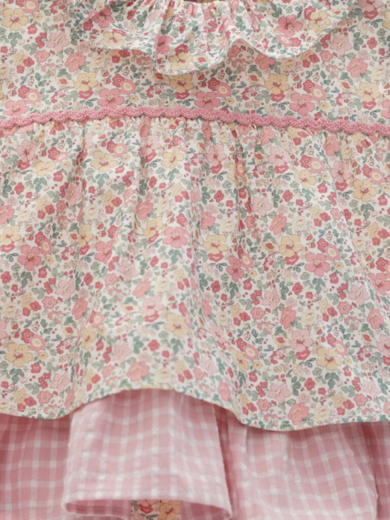 Detalle del conjunto bebé blusa efecto vestido y braga con flores