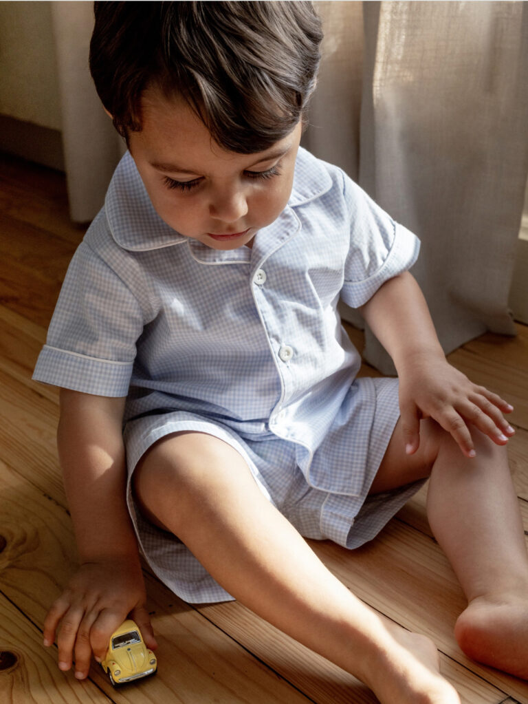 blue boy's gingham pajamas consisting of a short-sleeved shirt and matching shorts worn by a child