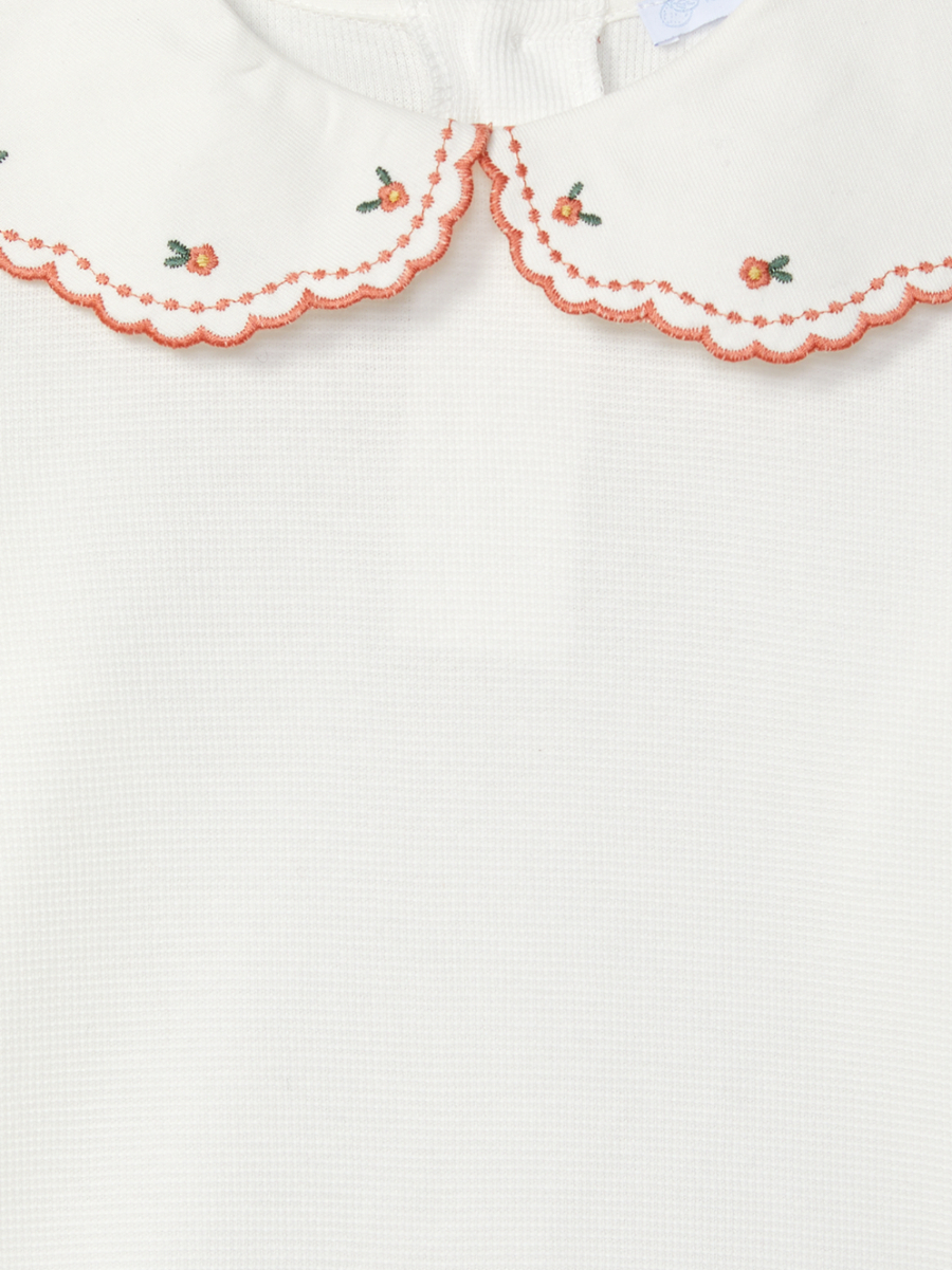 Détail de la blouse bébé fille à grand col brodé de fleurs et à liseré orange