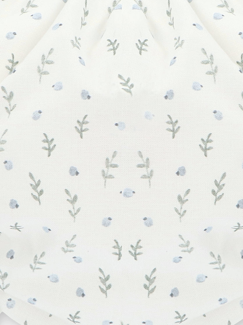 Détail du bloomer bébé fille à motif de petites fleurs bleues sur fond blanc
