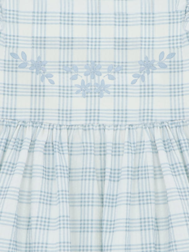 Détail de broderie de la robe fillette à carreaux bleu ciel et blancs