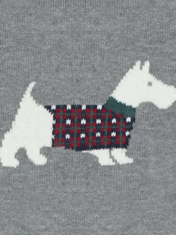 Détail du pull en maille gris à motif chien portant un manteau écossais