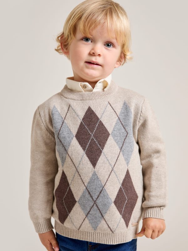 Pull garçon beige chiné en maille à motif de losanges porté par un garçon