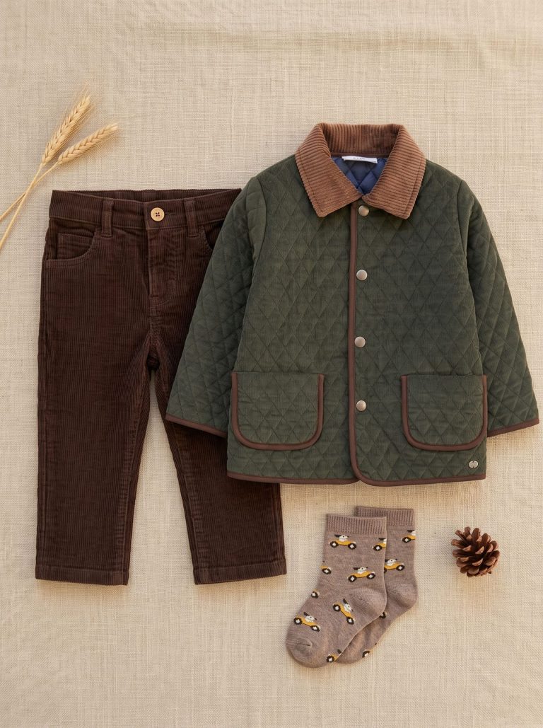 Tenue garçon avec veste matelassée vert foncé, pantalon marron et chaussettes à motifs